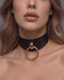 woman wearing a black leather bdsm collar with a large gold O-ring